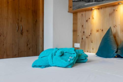 蒂罗尔州基希多夫Ferienhaus 12 im Feriendorf Kirchdorf的躺在床上的蓝色浴袍