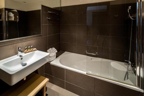锡富尔勒普拉日Hôtel Helios & SPA - Ile des Embiez的浴室配有白色浴缸和水槽