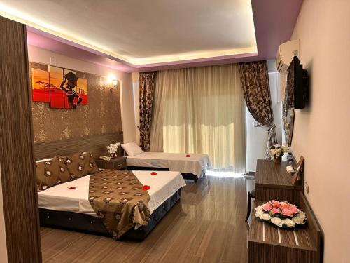SamandağıTruva Life Hotel的酒店客房设有两张床和一张桌子。