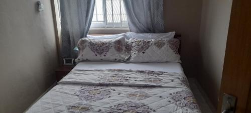 KasoaLovely 2-Bed Apartment in Kaosa的小卧室配有带枕头的床和窗户