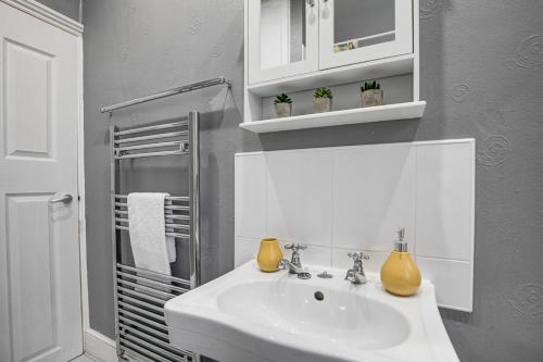 科尔维尔Ashby House的白色的浴室设有水槽和淋浴。