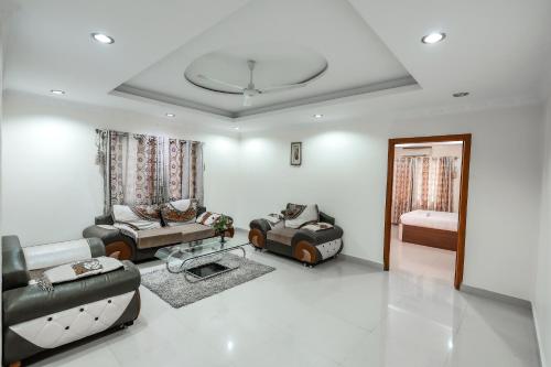 班加罗尔Falcon Suites Koramangala的客厅配有两张沙发和一张桌子