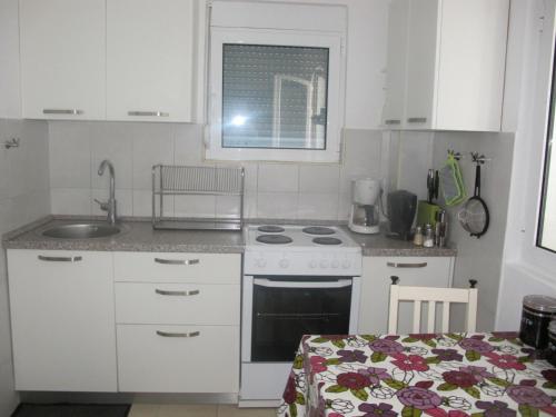 蒂瓦特Apartment Annika的厨房配有水槽和炉灶 顶部烤箱