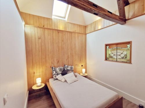 特鲁瓦Maison Vanier - Duplex - centre-ville - Mon Groom的一间卧室配有一张带木墙和窗户的床。