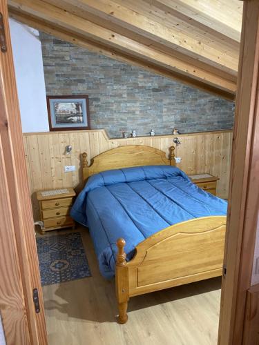 ArfaCasa Casteller 1-4 huéspedes的一间卧室配有一张带蓝色床单的木床。