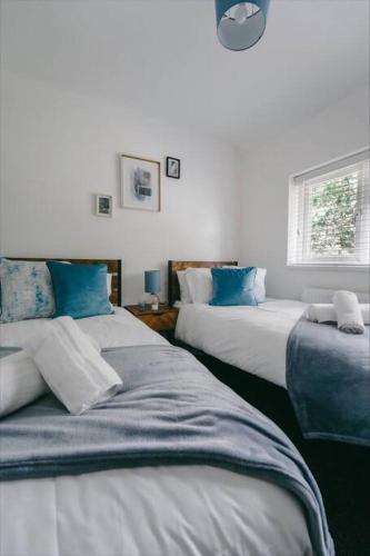 伯明翰Sapphire Lodge-Wyndale-WContractors Parking的一间卧室配有两张带蓝色枕头的床