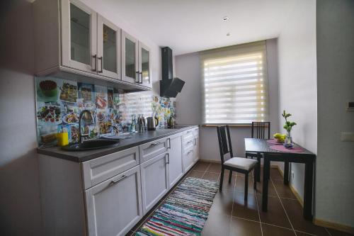 里加Studio apartment in private house的厨房配有白色橱柜、餐桌和用餐室