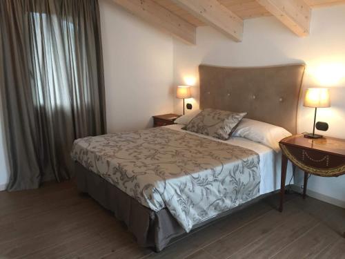 坎图La Villa Bianca Guest house的一间卧室配有一张床、两盏灯和一个窗户。