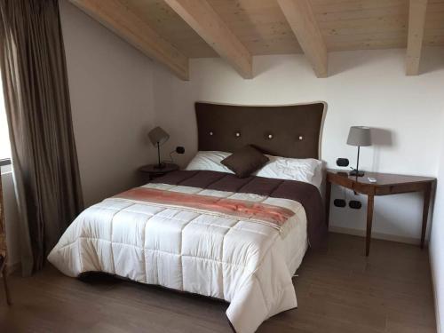 坎图La Villa Bianca Guest house的一间卧室设有一张大床和木制天花板