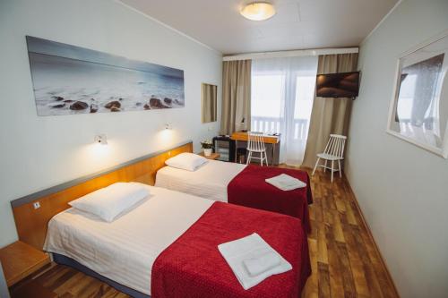 哈普萨卢Hotel Promenaadi的酒店客房设有两张床和一张桌子。