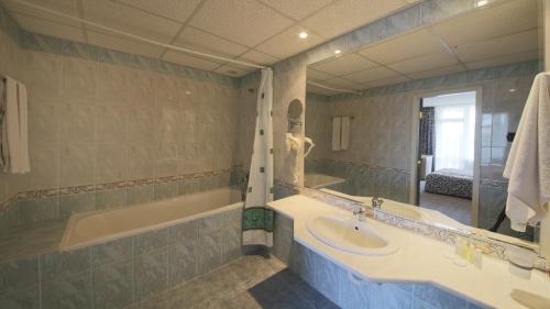 金沙希普卡酒店的浴室设有2个水槽、浴缸和镜子