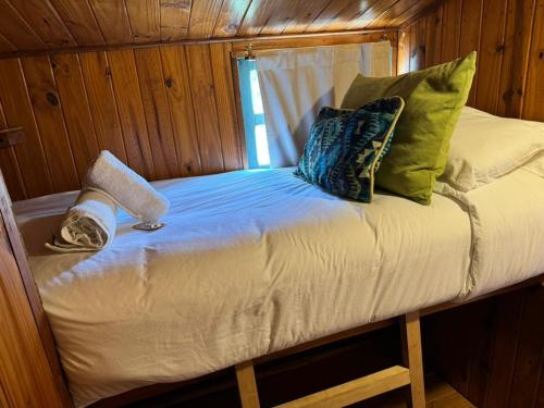 厄尔查尔坦科莫瓦加公寓的小木屋内的一张小床,配有枕头
