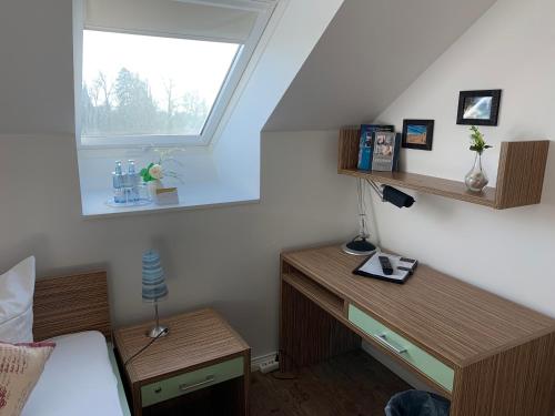 普特布斯Circus Hostal Putbus的一间卧室配有一张床、一张书桌和一个窗户。