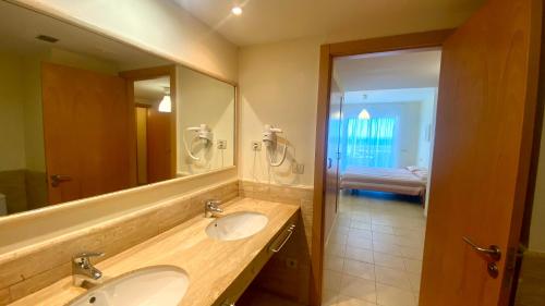拉梅特拉·德·玛尔Residencial Marina de Port的一间带两个盥洗盆和大镜子的浴室