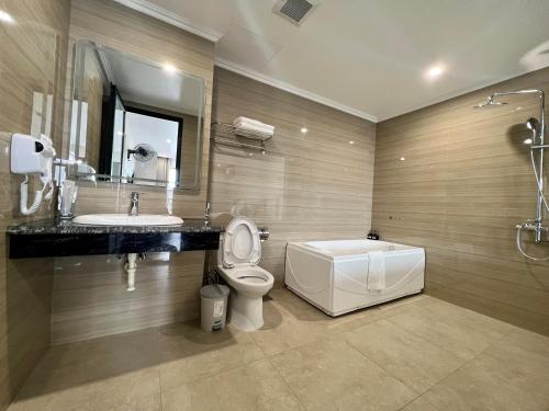 河内Grand Dragon Noi Bai Hotel的浴室配有卫生间、盥洗盆和浴缸。