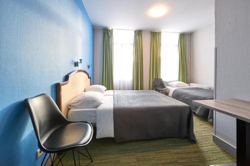 布鲁塞尔Hotel Derby MERODE的酒店客房,配有两张床和椅子