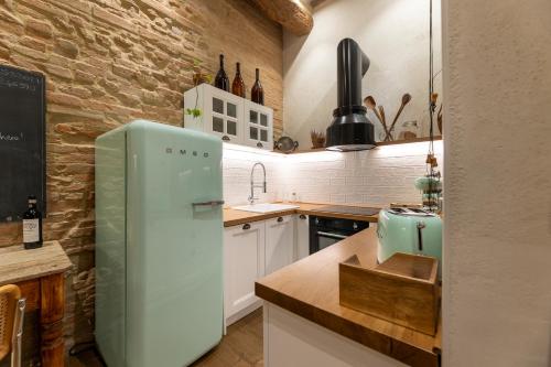 锡耶纳Al 24 Rosso的厨房配有绿色冰箱和砖墙