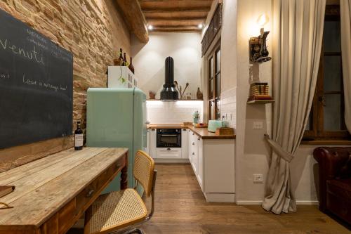 锡耶纳Al 24 Rosso的厨房配有木桌和冰箱。
