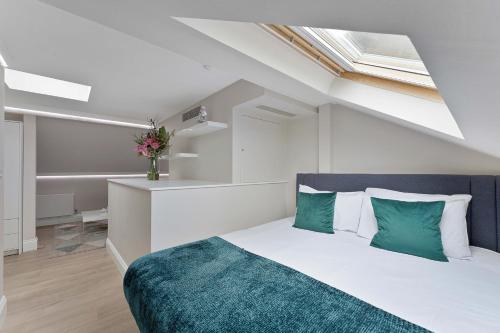 伦敦Cleveland Residences Russell Square的一间卧室配有带绿色和白色枕头的床