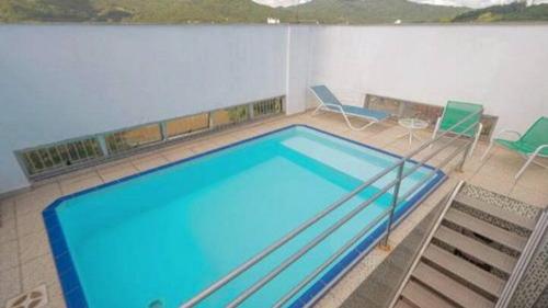南雅拉瓜Saint Sebastian Flat 206 - Com Hidro! até 4 pessoas, Duplex, no centro的一个带椅子的房间的大型游泳池