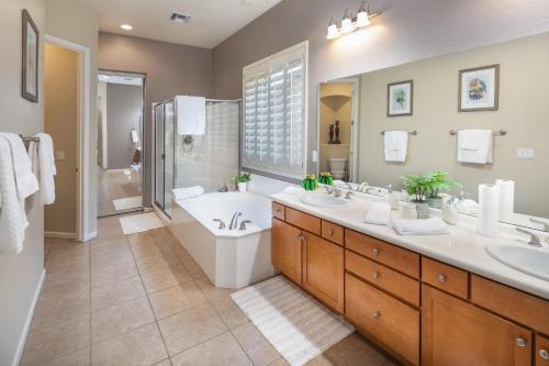 凤凰城Phoenix Vacation Rentals的一间带两个盥洗盆、浴缸和卫生间的浴室