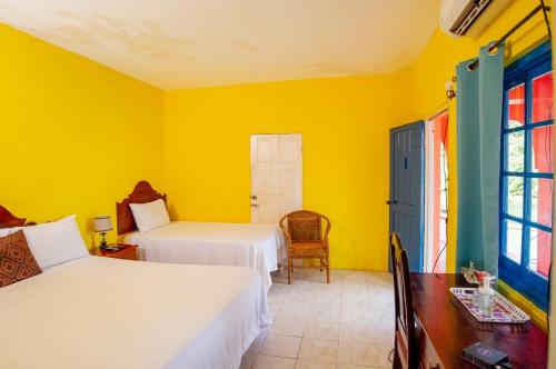 布莱克河Waterloo Guest House的一间卧室设有两张床和黄色的墙壁