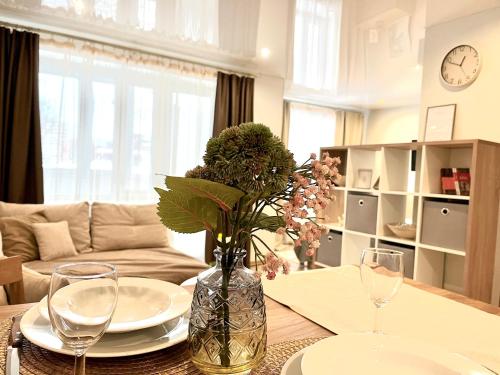 纳尔瓦Modern Charming Studio Narva Center的客厅配有带玻璃杯的桌子和鲜花花瓶
