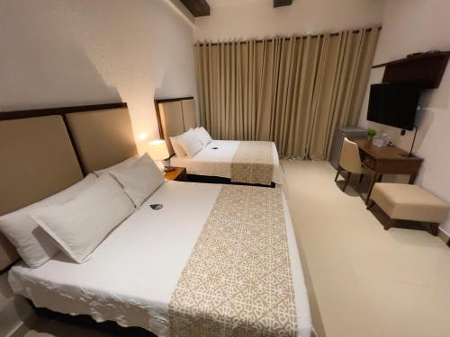 卡塔赫纳Hotel Dorado Plaza Centro Histórico的酒店客房设有两张床和电视。