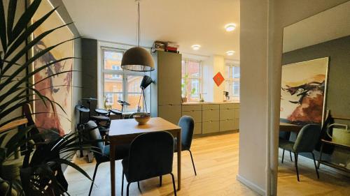 哥本哈根ApartmentInCopenhagen Apartment 1580的配有桌椅和厨房的房间