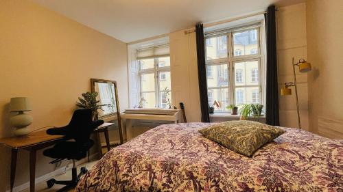 哥本哈根ApartmentInCopenhagen Apartment 1580的一间卧室配有一张床、一张书桌和一个窗户。