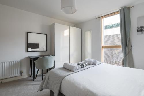 米尔顿凯恩斯City Stay Apartments - Vizion的白色卧室配有床和书桌