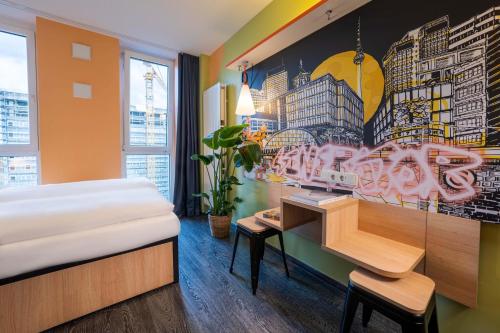 柏林Generator Berlin Alexanderplatz的一间卧室配有一张床、一张书桌和一幅画