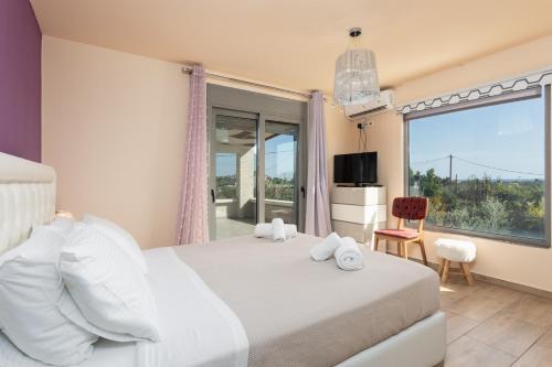 阿凡杜Villa Ammos的一间卧室设有一张床和一个大窗户