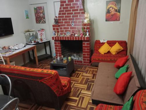 库斯科Posada de Mama的客厅设有砖砌壁炉和沙发。