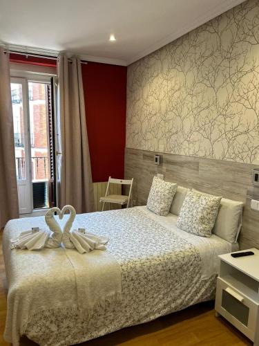 马德里Hostal New Dream Madrid的卧室里床边的两只天鹅