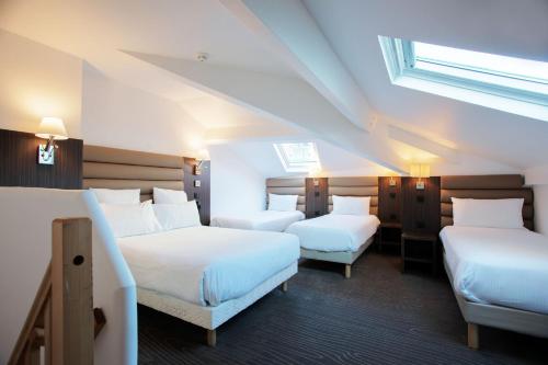 尼斯Hôtel & Appartements Monsigny的酒店客房设有两张床和窗户。