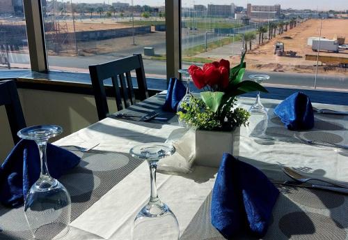 沙鲁拉Address Sharurah Hotel的一张桌子,上面放着酒杯和红花