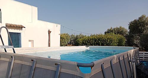 卡萨拉诺LA PILA masseria salentina con piscina 6 PL的庭院内的大型小型游泳池,设有木甲板