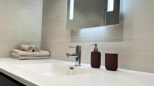 奥斯陆Brand new and modern apartment in Oslo center的浴室设有白色水槽和镜子