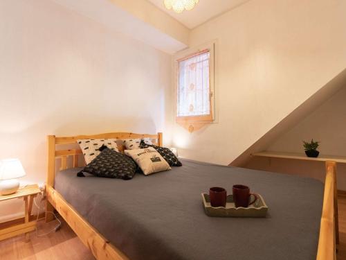 圣拉里苏朗Appartement Saint-Lary-Soulan, 1 pièce, 4 personnes - FR-1-296-350的卧室配有带枕头的床铺和窗户。