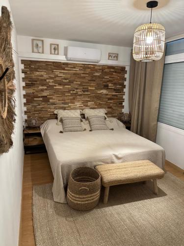 萨洛AGUILA DORADA的一间卧室设有一张大床和砖墙