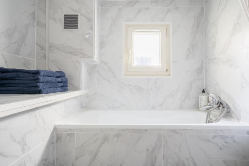 Soisy-sous-MontmorencyParis JO 2024 L élégante的白色的浴室设有浴缸和窗户。