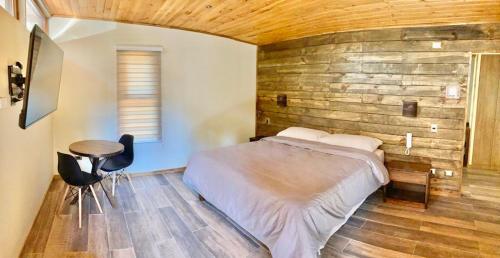 特木科Motel Los Robles的一间卧室设有一张床和木墙