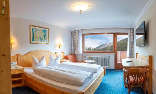 万丹斯Hotel Brunella的配有一张床、一张书桌和一扇窗户的酒店客房