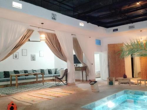 马拉喀什Riad Laila的带沙发和游泳池的客厅
