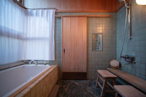 高山[Hida Takayama] Kiyomi-sou- - Vacation STAY 33671v的一间带浴缸的浴室和一扇木门