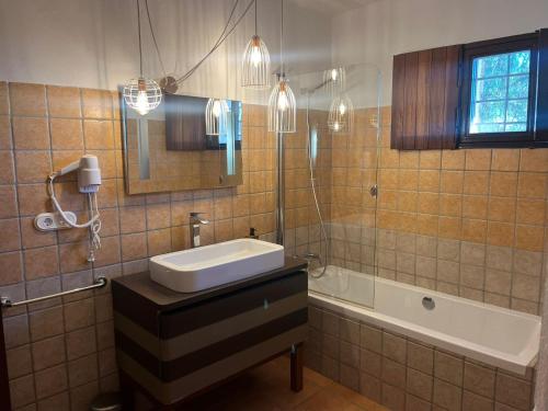 圣埃乌拉利亚Charming Villa Retreat in Ibiza - Bed & Breakfast Bliss的一间带水槽、浴缸和镜子的浴室