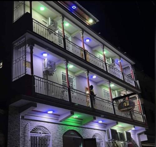 海地角Clientèle Hotel的两人晚上站在建筑物的阳台上