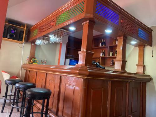 海地角Clientèle Hotel的一间木酒吧,里面设有凳子