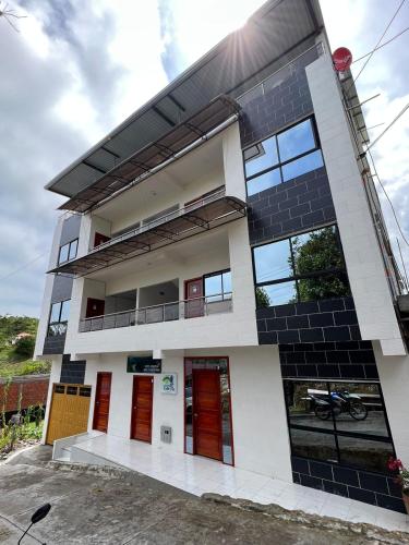 NorcasiaHOTEL NORCASIA RIOS Y AVENTURAS的一个带红色门和阳台的房子